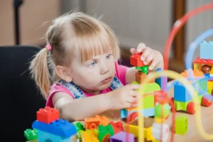 Małe dziecko bawi się klockami w trakcie samodzielnej zabawy