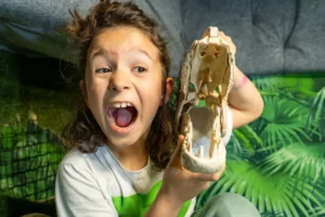 Dziewczynka bawi się w sali z dinozaurami